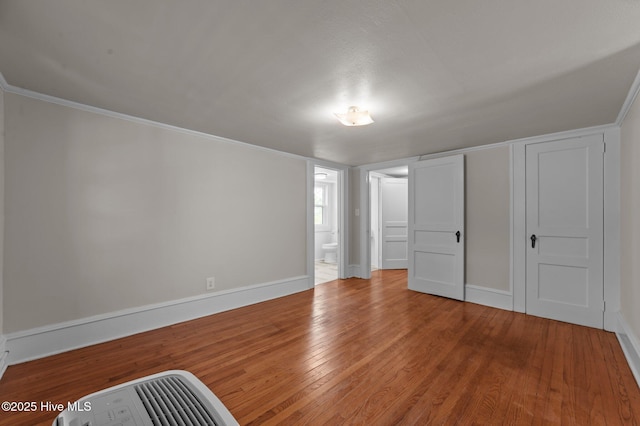 410 Craven St, Bath, NC 27808 - unfurnished bedroom featuring wood finished floors, baseboards, connected bathroom, and crown molding