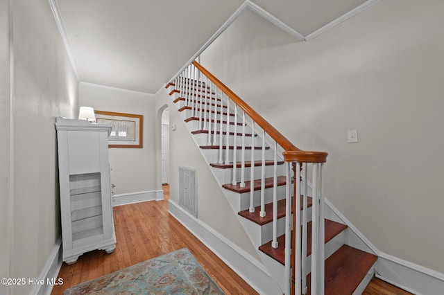 410 Craven St, Bath, NC 27808 - stairway with crown molding, wood finished floors, arched walkways, and baseboards