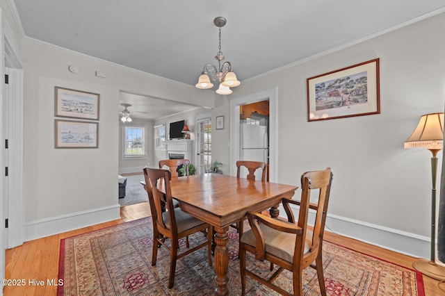 410 Craven St, Bath, NC 27808 - dining room with crown molding, a chandelier, a fireplace, light wood finished floors, and baseboards