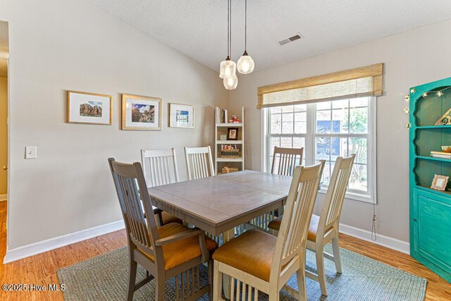 2 Beryl Cir, Pinehurst, NC 28374 - dining space with wood finished floors, baseboards, a textured ceiling, and a chandelier