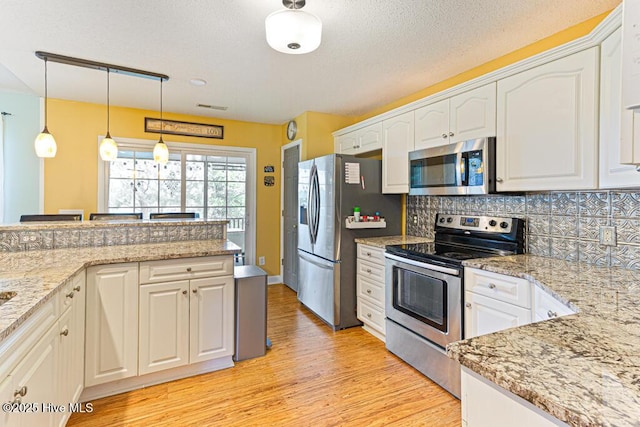 2 Beryl Cir, Pinehurst, NC 28374 - kitchen featuring stainless steel appliances, light wood-style flooring, white cabinetry, tasteful backsplash, and a textured ceiling