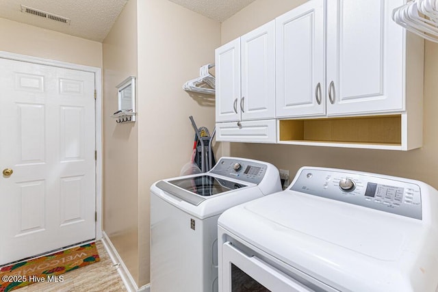2 Beryl Cir, Pinehurst, NC 28374 - laundry area featuring cabinet space, separate washer and dryer, a textured ceiling, and baseboards