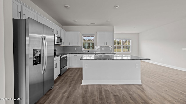 205 Lake Tyler Dr, New Bern, NC 28560 - kitchen featuring stainless steel appliances, a center island, wood finished floors, white cabinetry, and backsplash