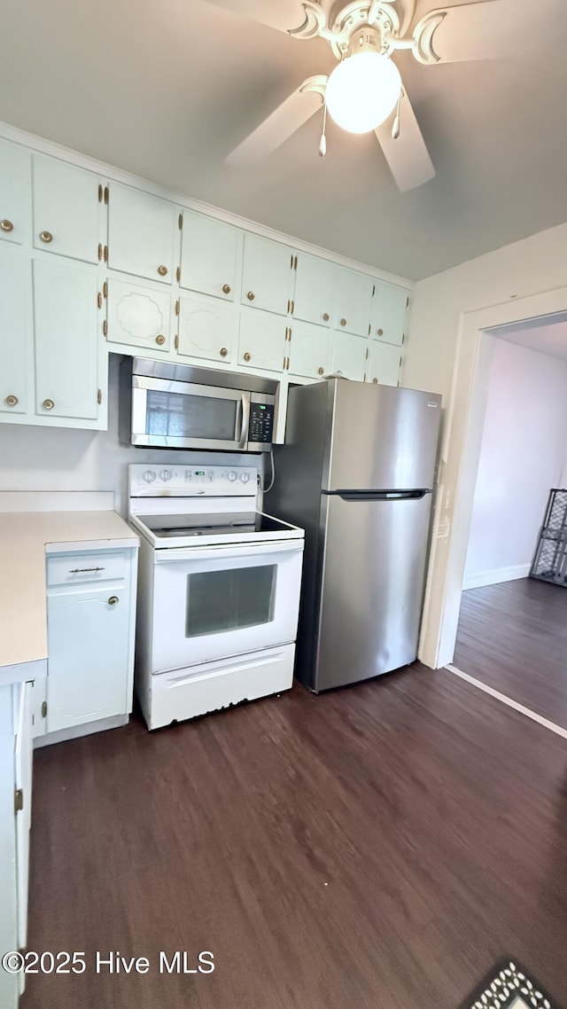 308 Terry St, Hamlet, NC 28345 - kitchen featuring appliances with stainless steel finishes, light countertops, dark wood-type flooring, ceiling fan, and white cabinetry