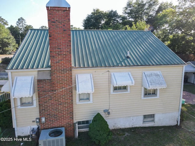 308 Terry St, Hamlet, NC 28345 - view of property exterior featuring a chimney, central air condition unit, and metal roof