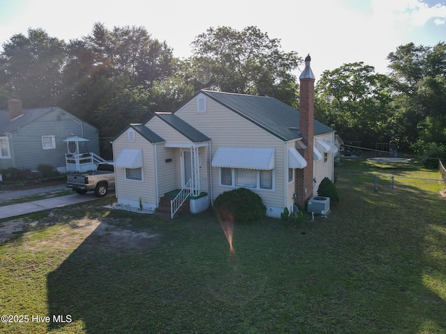 308 Terry St, Hamlet, NC 28345 - bungalow-style house featuring a front lawn, central air condition unit, a chimney, and view of wooded area
