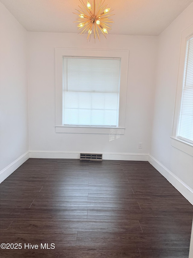 308 Terry St, Hamlet, NC 28345 - empty room featuring a chandelier, baseboards, and dark wood-style floors