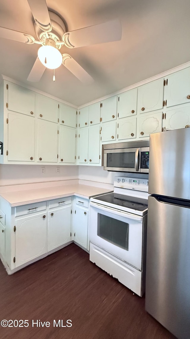 308 Terry St, Hamlet, NC 28345 - kitchen featuring stainless steel appliances, dark wood finished floors, light countertops, a ceiling fan, and white cabinets