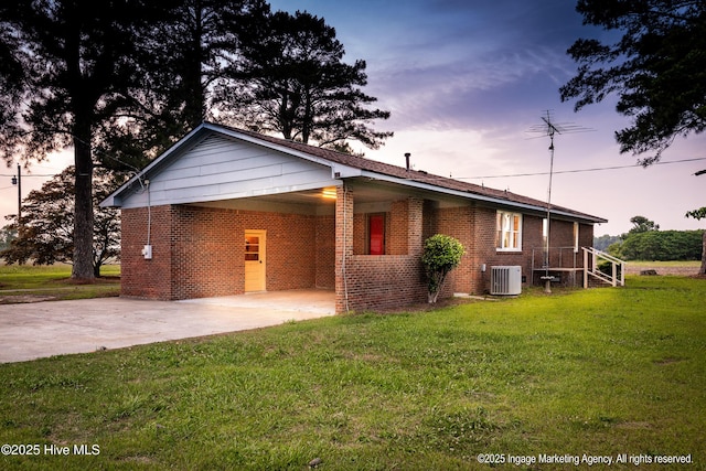 1363 Robert Everett Rd, Robersonville, NC 27871 - ranch-style house featuring central AC unit, brick siding, concrete driveway, a lawn, and an attached carport
