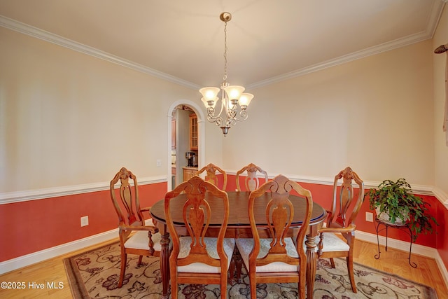 4029 Berberis Way, Wilmington, NC 28412 - dining area featuring crown molding, baseboards, wood finished floors, a chandelier, and arched walkways