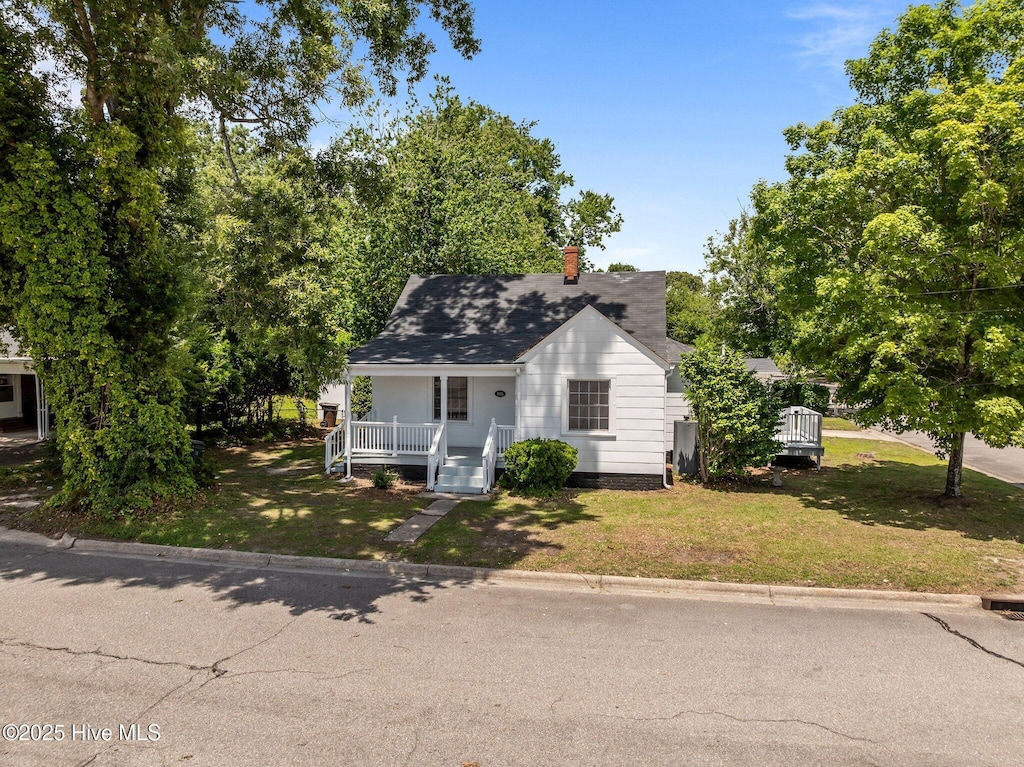 306 Oak Dr, Tarboro, NC 27886 - view of front of home with covered porch, a front yard, a chimney, and a shingled roof