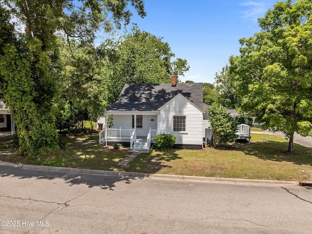 306 Oak Dr, Tarboro, NC 27886 - view of front of home with covered porch, a front yard, a chimney, and a shingled roof