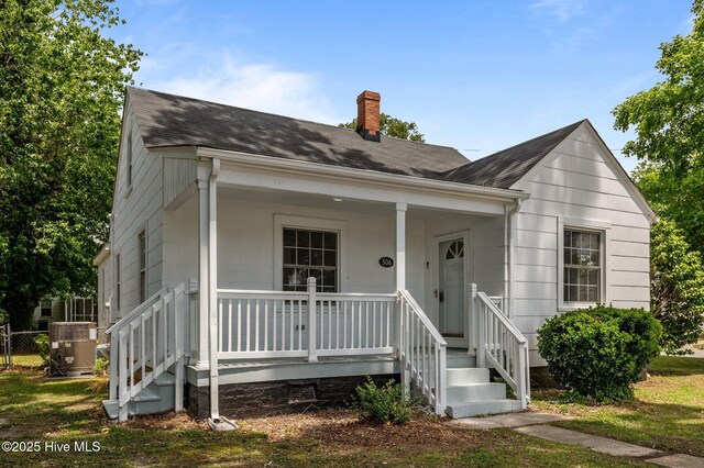 306 Oak Dr, Tarboro, NC 27886 - view of front facade with a chimney, a porch, roof with shingles, and central AC