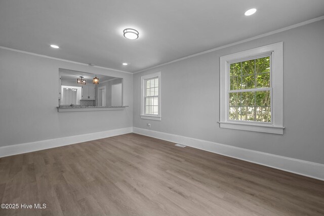 306 Oak Dr, Tarboro, NC 27886 - unfurnished living room featuring crown molding, baseboards, wood finished floors, and recessed lighting
