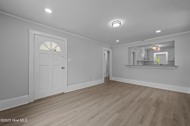 306 Oak Dr, Tarboro, NC 27886 - unfurnished living room featuring ornamental molding, wood finished floors, baseboards, recessed lighting, and a chandelier