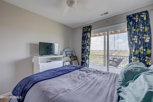 316 Bay Cir, North Topsail Beach, NC 28460 - bedroom featuring access to outside, a textured ceiling, baseboards, and a ceiling fan