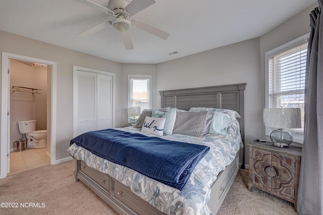 316 Bay Cir, North Topsail Beach, NC 28460 - bedroom with light carpet, a closet, ensuite bath, ceiling fan, and baseboards