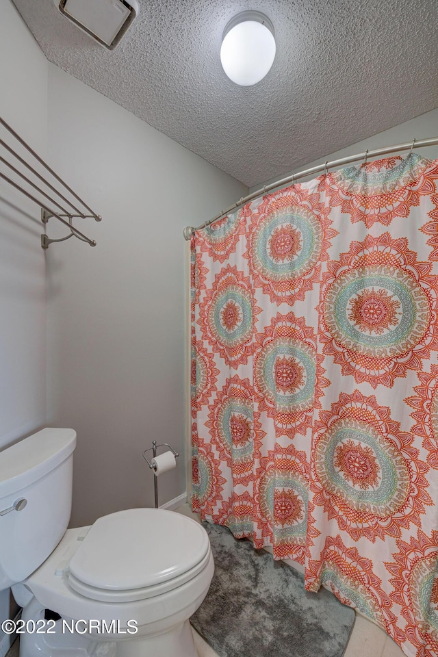 316 Bay Cir, North Topsail Beach, NC 28460 - full bath with toilet, a textured ceiling, and a shower with shower curtain