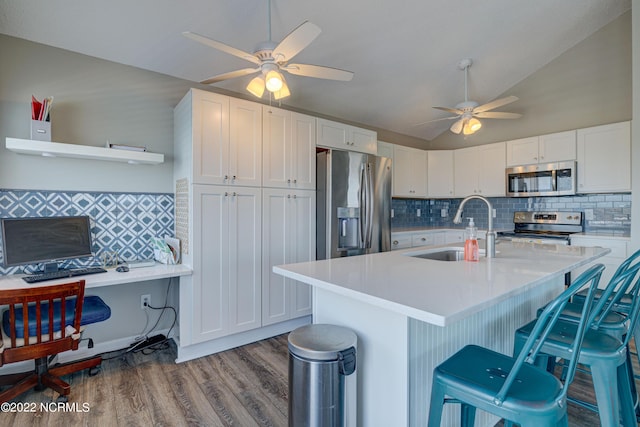 316 Bay Cir, North Topsail Beach, NC 28460 - kitchen with stainless steel appliances, a sink, a ceiling fan, decorative backsplash, and vaulted ceiling