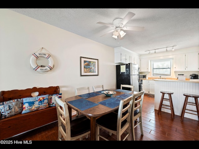 1013 Carolina Beach Ave N Unit 1F, Carolina Beach, NC 28428 - dining space with dark wood-style flooring, a textured ceiling, ceiling fan, and track lighting