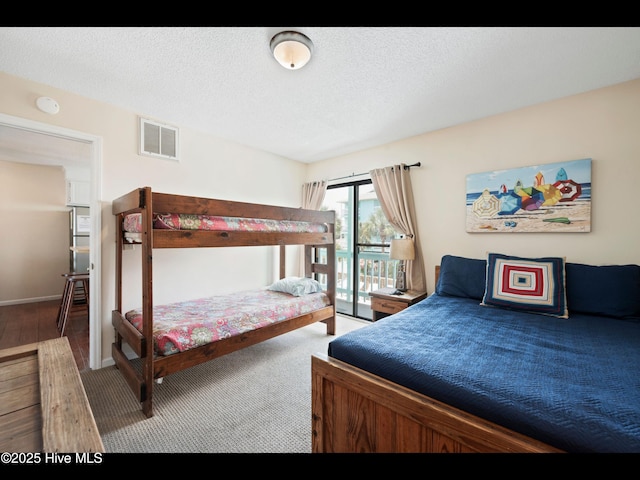 1013 Carolina Beach Ave N Unit 1F, Carolina Beach, NC 28428 - bedroom with access to exterior, wood finished floors, and a textured ceiling