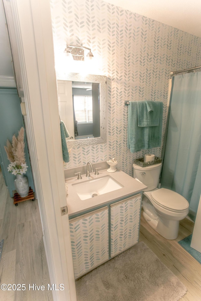 132 Charlton Rd, Hubert, NC 28539 - full bath featuring wood finished floors, wallpapered walls, toilet, vanity, and curtained shower