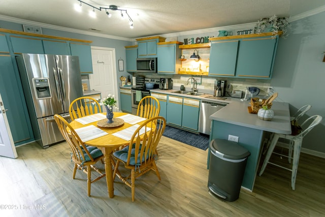 132 Charlton Rd, Hubert, NC 28539 - kitchen with appliances with stainless steel finishes, a peninsula, a sink, crown molding, and light wood finished floors