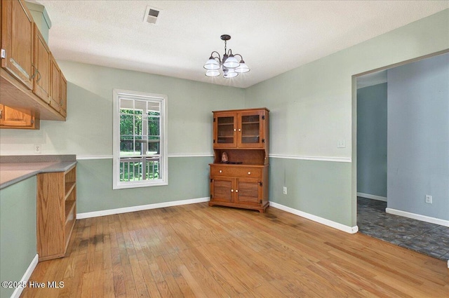 2 Pinewood Dr, Calabash, NC 28467 - unfurnished dining area with light wood-style floors, a chandelier, and baseboards