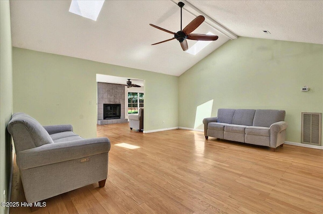 2 Pinewood Dr, Calabash, NC 28467 - living area with ceiling fan, a skylight, light wood-type flooring, beam ceiling, and a tile fireplace