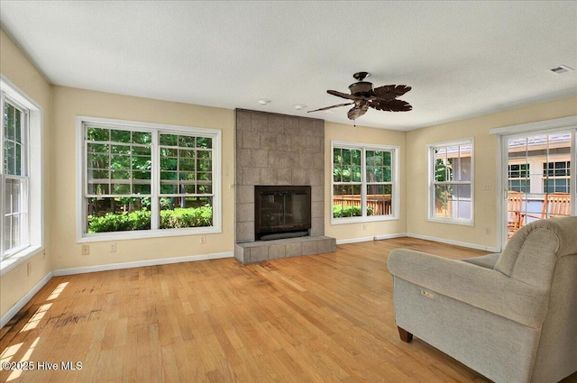 2 Pinewood Dr, Calabash, NC 28467 - living area with baseboards, light wood finished floors, ceiling fan, a textured ceiling, and a fireplace