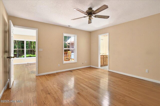 2 Pinewood Dr, Calabash, NC 28467 - unfurnished room featuring light wood-type flooring, plenty of natural light, ceiling fan, baseboards, and a textured ceiling