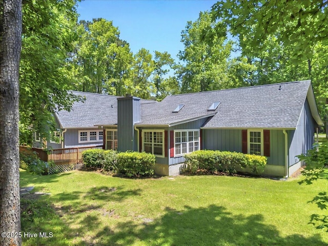2 Pinewood Dr, Calabash, NC 28467 - rear view of house with a shingled roof, a deck, a lawn, and a chimney