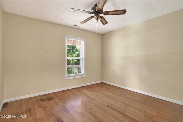 2 Pinewood Dr, Calabash, NC 28467 - empty room with wood finished floors, baseboards, a ceiling fan, and a textured ceiling