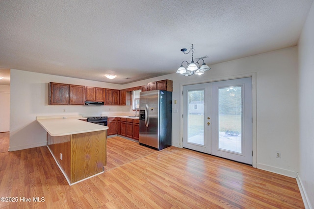 4448 Jamey Ct, Wilmington, NC 28405 - kitchen featuring stainless steel fridge with ice dispenser, a peninsula, black electric range oven, light wood-style floors, and a textured ceiling