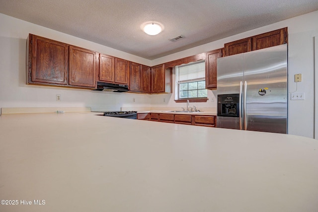 4448 Jamey Ct, Wilmington, NC 28405 - kitchen with stainless steel refrigerator with ice dispenser, under cabinet range hood, light countertops, range with electric stovetop, and a textured ceiling