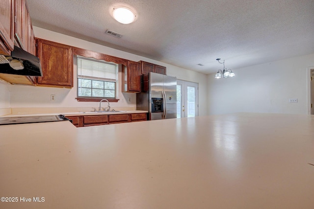 4448 Jamey Ct, Wilmington, NC 28405 - kitchen featuring stainless steel fridge with ice dispenser, a sink, under cabinet range hood, a textured ceiling, and brown cabinetry