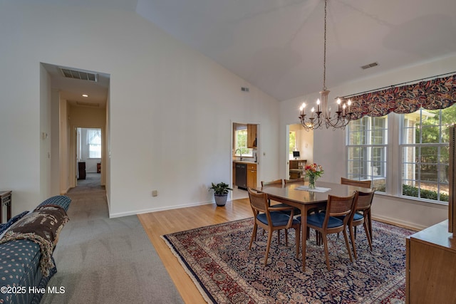 315 Thomas Pl, Washington, NC 27889 - dining space featuring a chandelier, baseboards, high vaulted ceiling, and light wood-style floors