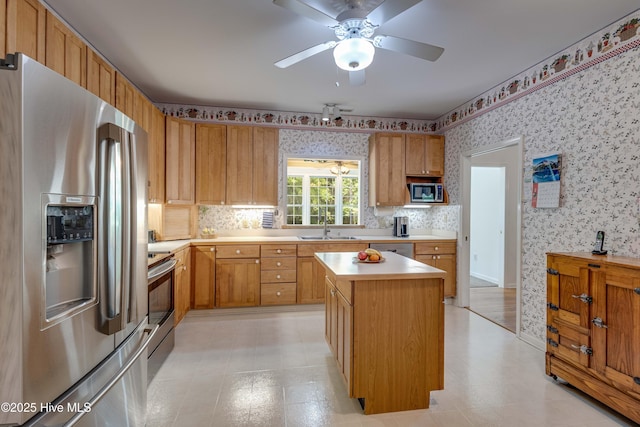 315 Thomas Pl, Washington, NC 27889 - kitchen with appliances with stainless steel finishes, wallpapered walls, a sink, light countertops, and a kitchen island