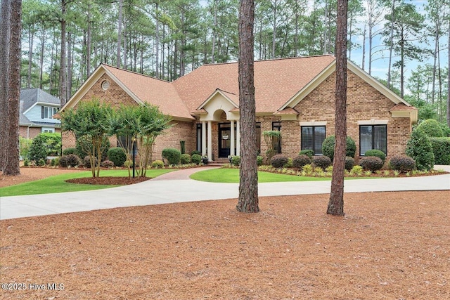 21 Abbottsford Dr, Pinehurst, NC 28374 - view of front of house featuring brick siding, curved driveway, and roof with shingles