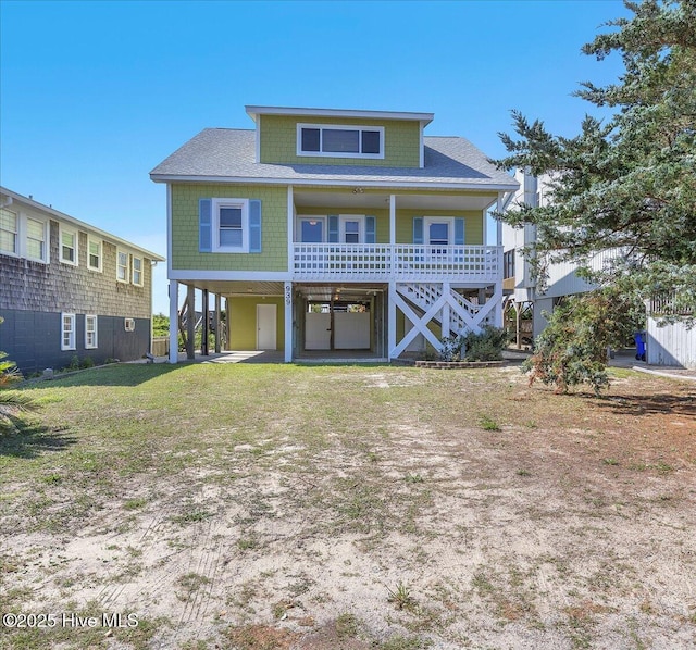 939 Ocean Blvd W, Holden Beach, NC 28462 - view of front of property with a carport, a shingled roof, and a front yard