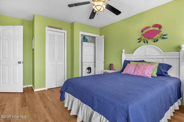 939 Ocean Blvd W, Holden Beach, NC 28462 - bedroom featuring stacked washer / dryer, wood finished floors, ceiling fan, a textured ceiling, and a closet
