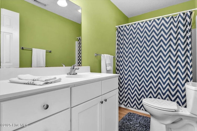 939 Ocean Blvd W, Holden Beach, NC 28462 - bathroom with toilet, vanity, a textured ceiling, and a shower with curtain
