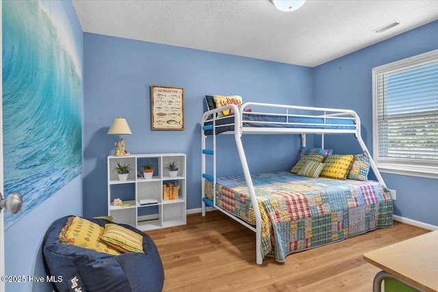 939 Ocean Blvd W, Holden Beach, NC 28462 - bedroom with wood finished floors, baseboards, and a textured ceiling