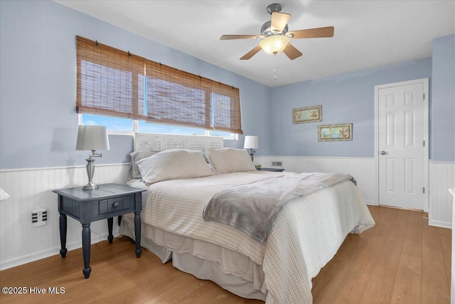 939 Ocean Blvd W, Holden Beach, NC 28462 - bedroom featuring a wainscoted wall, wood finished floors, and ceiling fan
