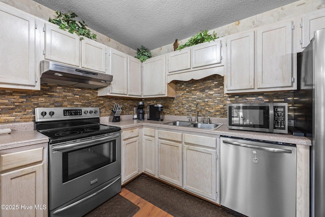 119 Cobblestone Trl, Jacksonville, NC 28546 - kitchen featuring under cabinet range hood, appliances with stainless steel finishes, a sink, light countertops, and dark wood-style floors