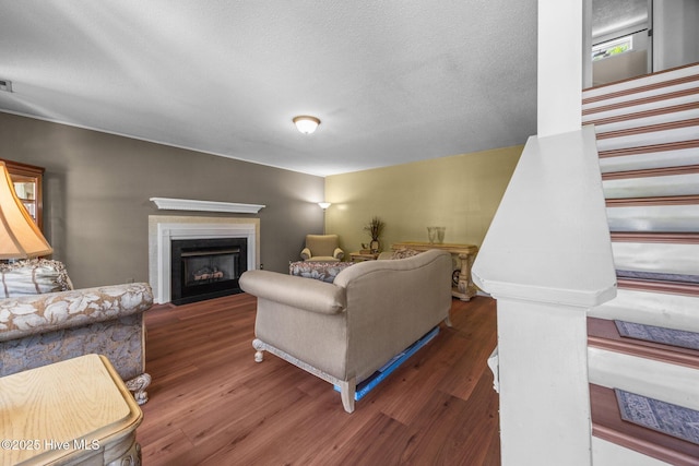 119 Cobblestone Trl, Jacksonville, NC 28546 - living area with wood finished floors, a fireplace with flush hearth, stairway, and a textured ceiling