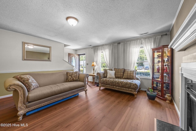 119 Cobblestone Trl, Jacksonville, NC 28546 - living area featuring a fireplace with flush hearth, a textured ceiling, wood finished floors, and baseboards