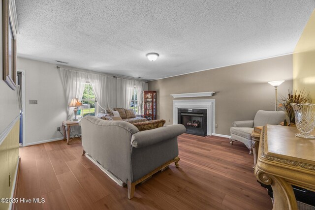 119 Cobblestone Trl, Jacksonville, NC 28546 - living area featuring wood finished floors, a fireplace, baseboards, and a textured ceiling