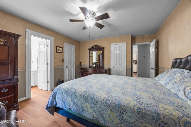 119 Cobblestone Trl, Jacksonville, NC 28546 - bedroom featuring light wood-style floors, connected bathroom, a ceiling fan, and a textured ceiling