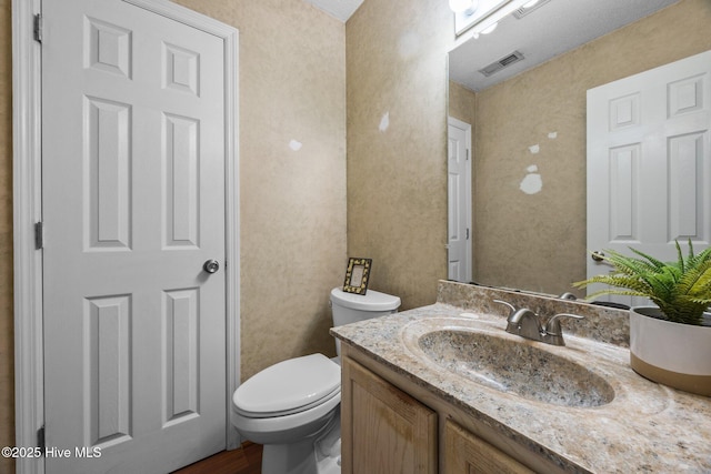 119 Cobblestone Trl, Jacksonville, NC 28546 - bathroom featuring toilet, vanity, wood finished floors, and a textured wall